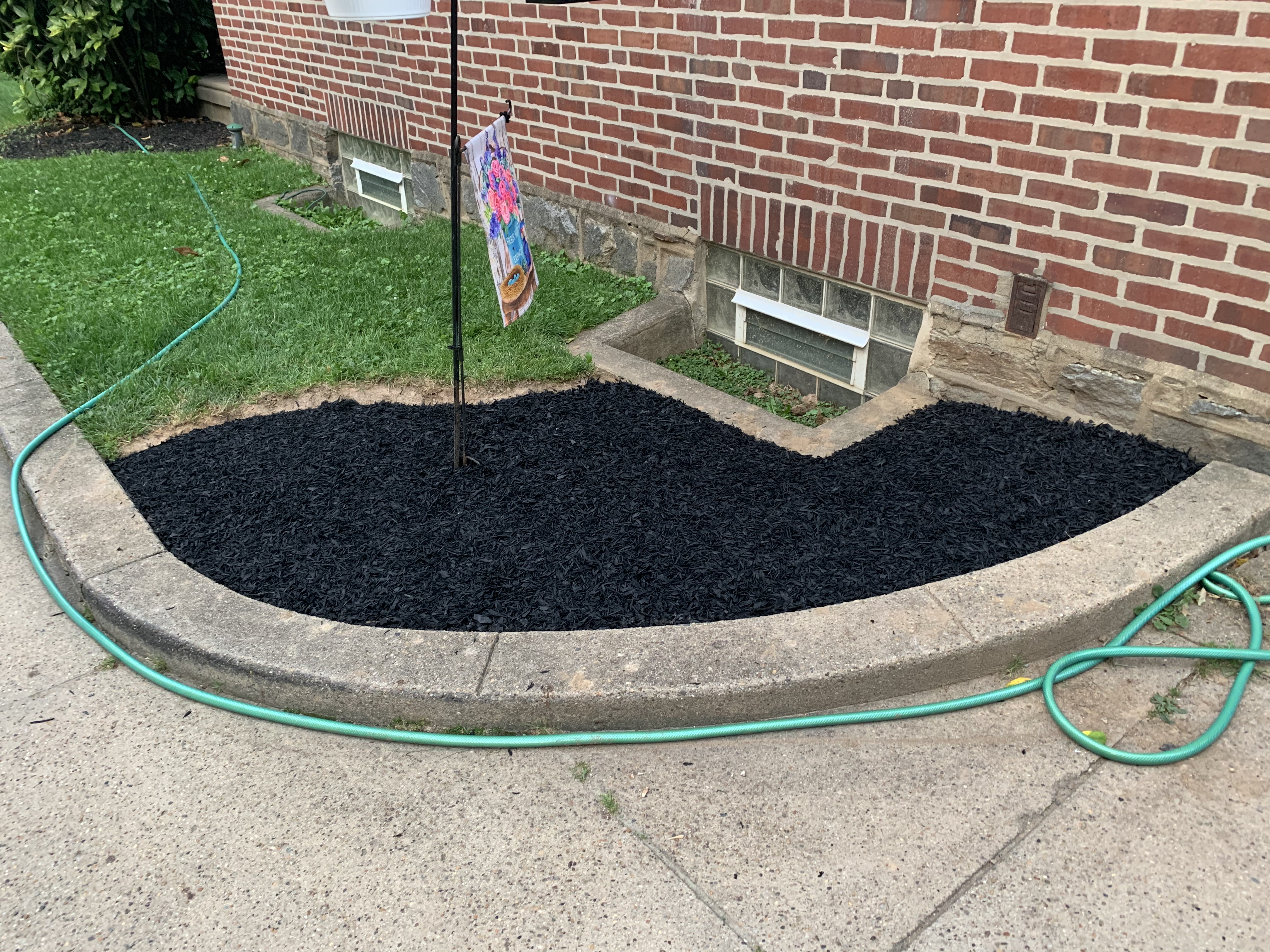 Fresh black mulch bed around flag pole base