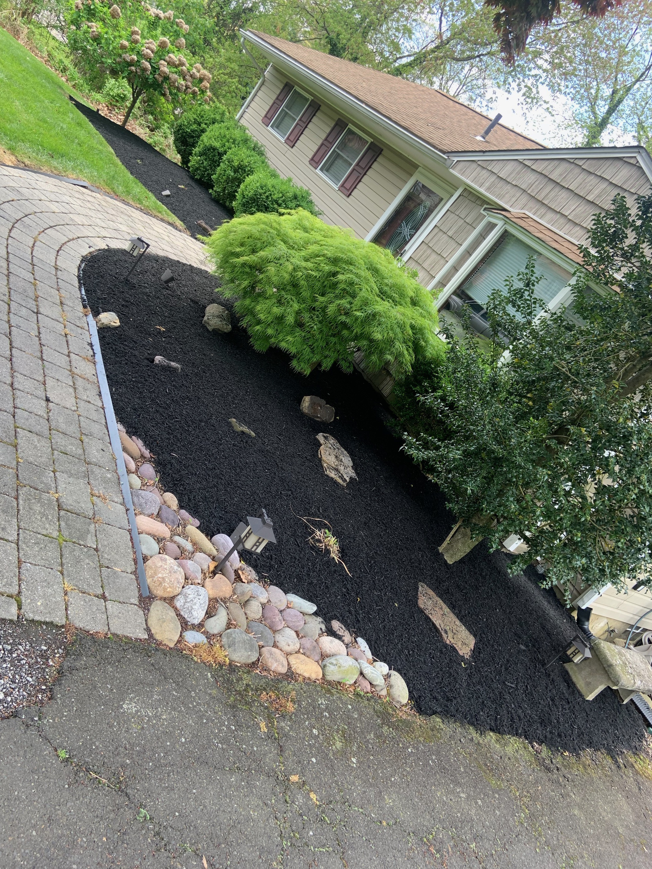 Mulch bed with river rock border along walkway