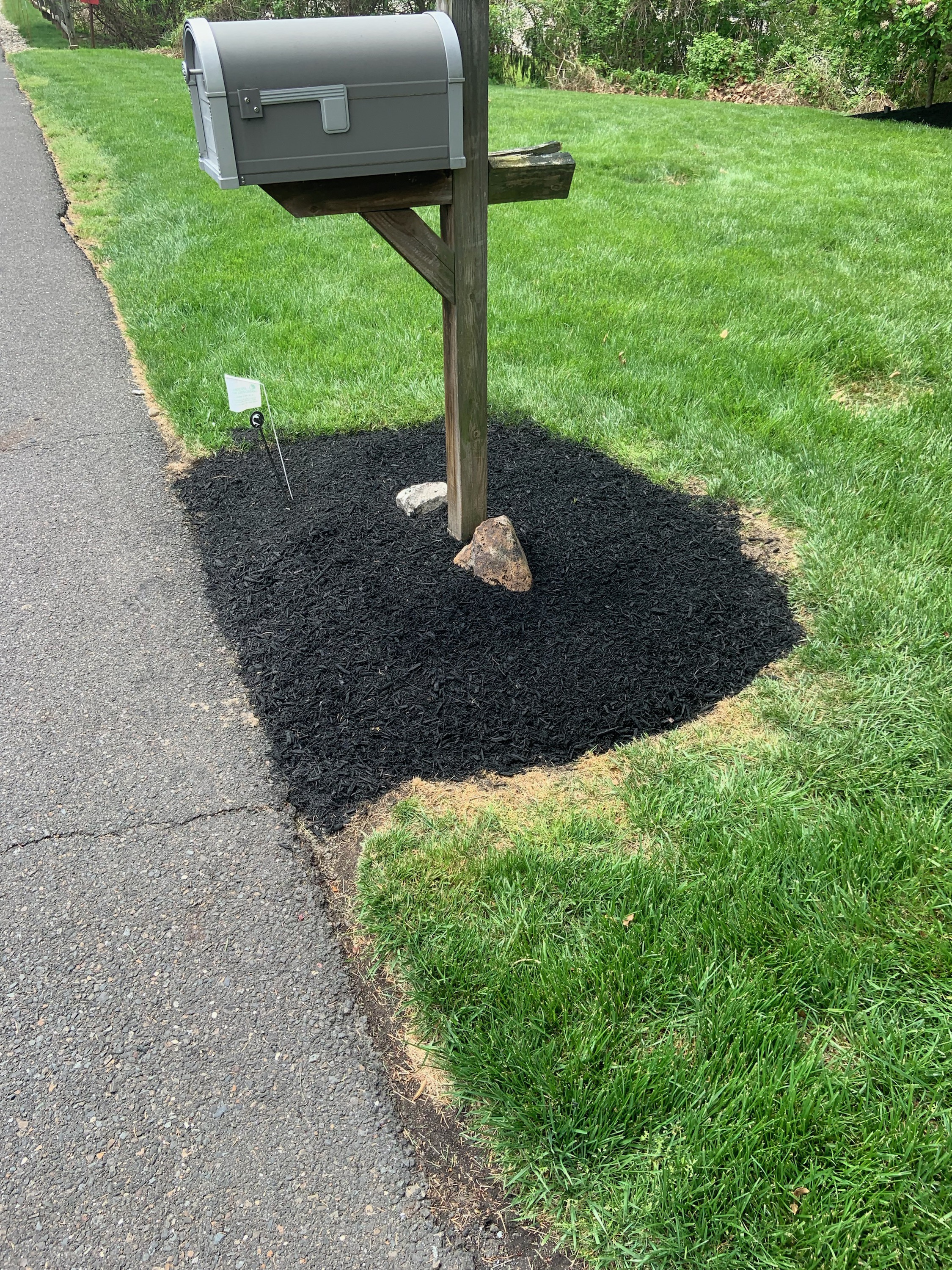 Mailbox base with fresh mulch and accent stone