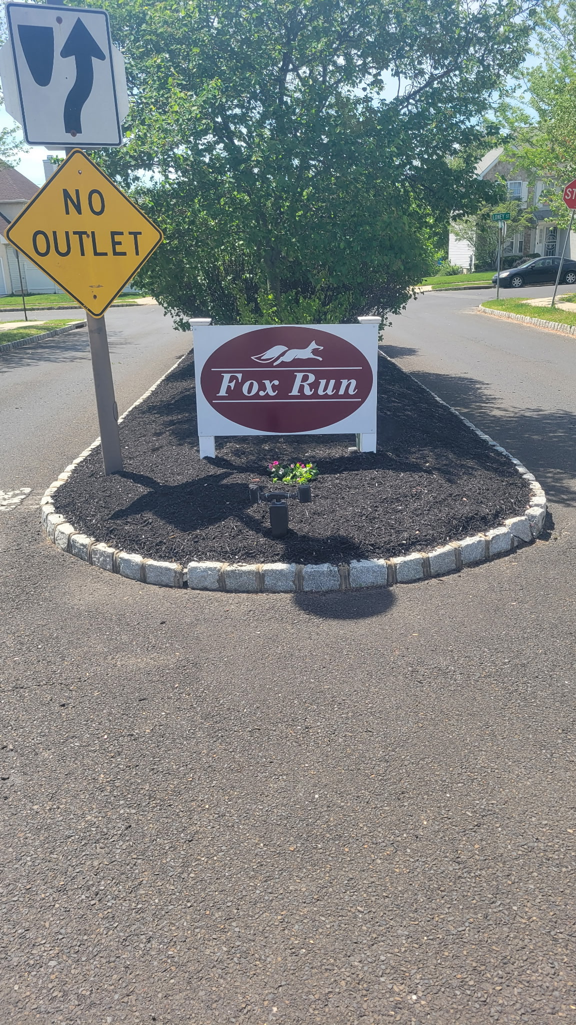 Fox Run community entrance sign with fresh mulch and stone border
